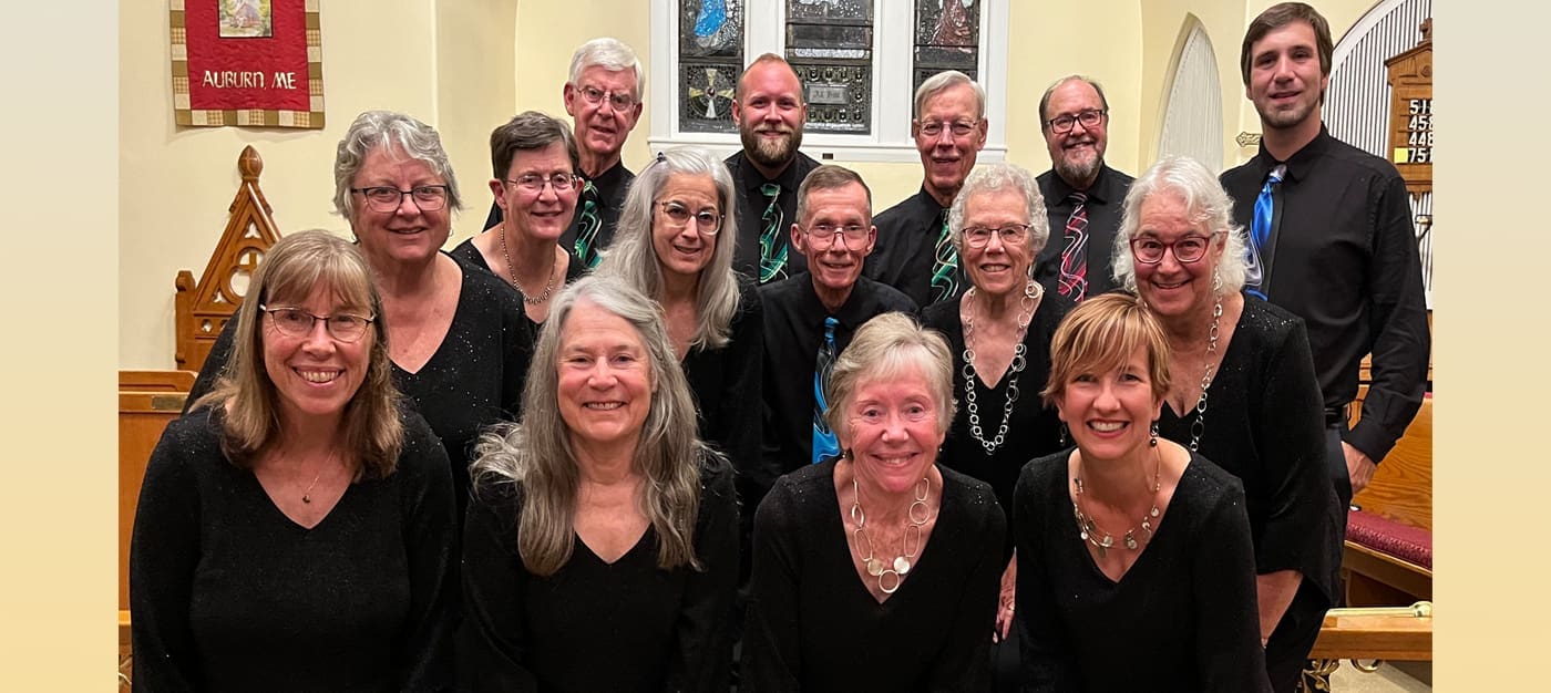 chamber Smiling group of adults dressed in black posing for a photo indoors.